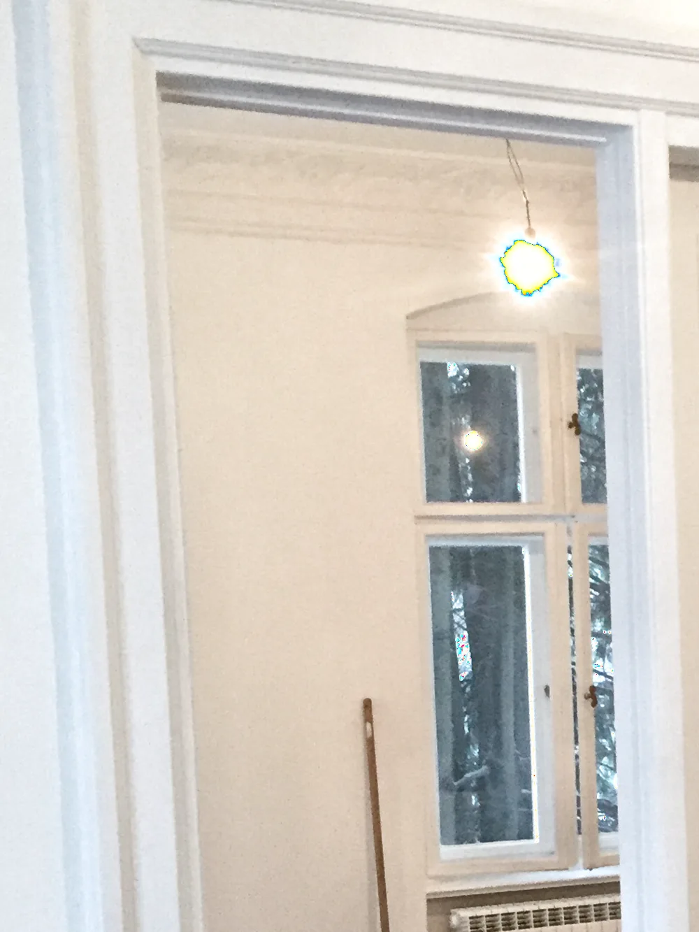 Weiße verglaste Trennwand mit Blick auf ein Sprossenfenster