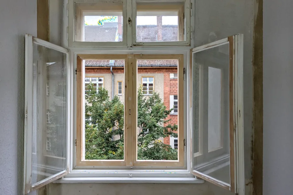 Aufgearbeitetes Holzfenster mit Blick ins Grüne